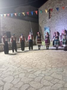 Η χορευτική ομάδα του Λαϊκού Εργαστηρίου Πάτρας σε σειρά στα λιθόστρωτα της Χαλανδρίτσας, 2019