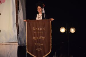 Μέλος του Λαϊκού Εργαστηρίου Πάτρας με το λάβαρο της ομάδας στη σκηνή, 2021