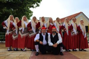 Χορευτές του Λαϊκού Εργαστηρίου Πάτρας με το πανό της ομάδας, πλατεία Οβρυάς 2024