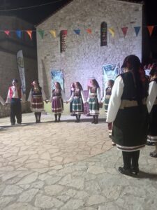 Η χορευτική ομάδα του Λαϊκού Εργαστηρίου Πάτρας σε σειρά στα λιθόστρωτα της Χαλανδρίτσας, 2019