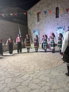 Η χορευτική ομάδα του Λαϊκού Εργαστηρίου Πάτρας σε σειρά στα λιθόστρωτα της Χαλανδρίτσας, 2019