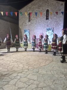Η χορευτική ομάδα του Λαϊκού Εργαστηρίου Πάτρας σε σειρά στα λιθόστρωτα της Χαλανδρίτσας, 2019
