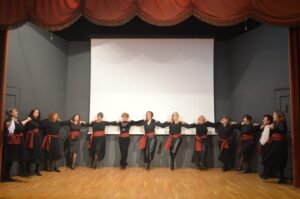 Χορευτές του Λαϊκού Εργαστηρίου Πάτρας σε παραδοσιακό χορό στη σκηνή, 2024