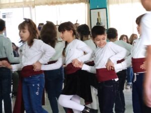 Παιδιά χορεύουν παραδοσιακούς χορούς μπροστά στους γονείς τους, Λαϊκό Εργαστήρι Πάτρας 2023