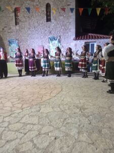 Η χορευτική ομάδα του Λαϊκού Εργαστηρίου Πάτρας σε σειρά στα λιθόστρωτα της Χαλανδρίτσας, 2019
