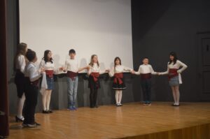 Χορευτές του Λαϊκού Εργαστηρίου Πάτρας σε παραδοσιακό χορό στη σκηνή, 2024