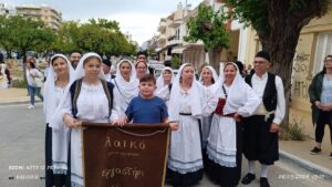 Χορευτές του Λαϊκού Εργαστηρίου Πάτρας σε ομαδική φωτογραφία με το πανό της ομάδας, 2024