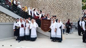 Χορευτές του Λαϊκού Εργαστηρίου Πάτρας σε ομαδική φωτογραφία με το πανό της ομάδας, 2024