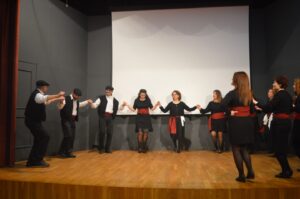 Χορευτές του Λαϊκού Εργαστηρίου Πάτρας σε παραδοσιακό χορό στη σκηνή, 2024