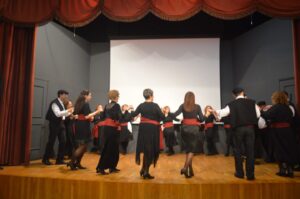Χορευτές του Λαϊκού Εργαστηρίου Πάτρας σε παραδοσιακό χορό στη σκηνή, 2024