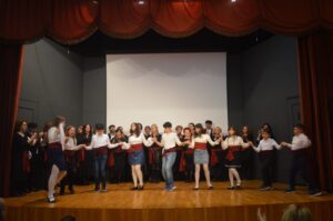 Χορευτές του Λαϊκού Εργαστηρίου Πάτρας σε παραδοσιακό χορό στη σκηνή, 2024
